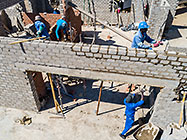 aerial view of 4x4 Unimog with crane installing house roof wooden beams