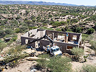 aerial view of 4x4 Unimog with crane installing house roof wooden beams