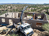 aerial view of 4x4 Unimog with crane installing house roof wooden beams