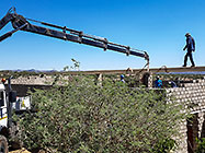 4x4 Unimog with crane installing house roof wooden beams