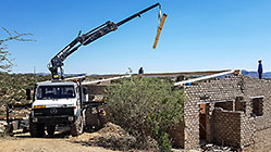 4x4 Unimog with crane installing house roof wooden beams