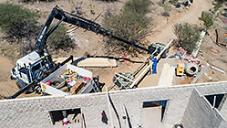 aerial view of 4x4 Unimog with crane installing house roof wooden beams