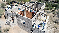 aerial view of 4x4 Unimog with crane installing house roof wooden beams