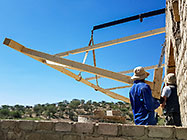 4x4 Unimog with crane installing house roof wooden beams