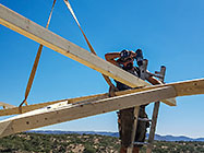 4x4 Unimog with crane installing house roof wooden beams