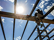 worker sealing house roof wooden beams