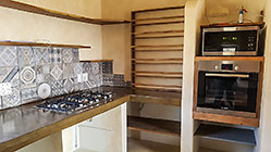 house kitchen countertops with prosopis wooden shelves, tiles, stove & oven