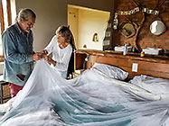 Paul & Anne making mosquito sheet for house master bedroom