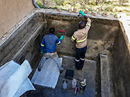 Donald & Sedney laying fiberglass mesh on house pool walls