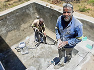 Donald & Sedney laying fiberglass mesh on house pool walls