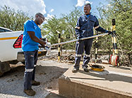 environmental field assistants taking borehole water sample