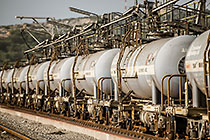 worker walking along railway | train of wagons containing sulphuric acid