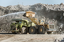 water spraying on digger loader loading 320T truck from stock pile