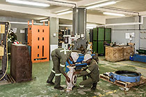 workers repairing pump in workshop