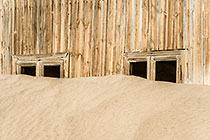 Bogenfels ghost town - sand covering old wooden house windows