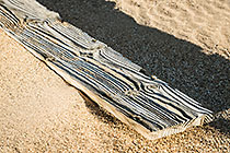 sand blasted wooden planck in sand
