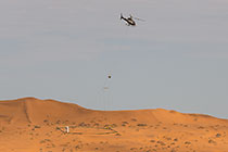 helicopter flying with SkyTEM rig over sand dunes