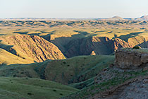 hills covered with grass at sunset