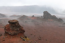 rock formations on lava field under rain & clouds