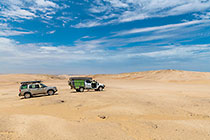 ranger-camper & disco driving through sandy desert