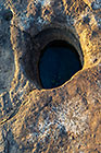 round hole on rock near white lichens