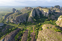huge granite boulders between green vegetation