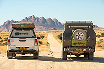 ranger camper on road to massif granite monolith Spitzkoppe mountain