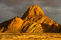 Spitzkoppe mountain under clouds at sunset