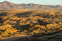 ranger camper & 4x4 at campsite near granite monolith mountain at sunrise