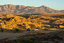 ranger camper & 4x4 at campsite near granite monolith mountain at sunrise