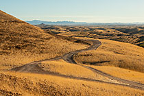 track through golden dry grass on hills