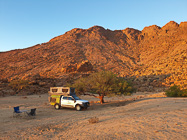 camper ranger at wildcamp near rocky hill at sunset