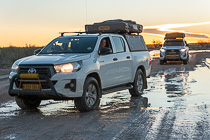 camping cars on wet road at sunset
