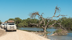 camping cars on gravel road next to water