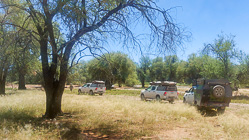 camping cars & ranger camper driving under trees next to river