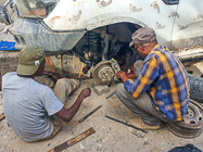mechanics repairing ranger camper with brocken shock