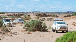 camping cars driving in sandy riverbed
