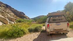 camping cars driving in sandy riverbed