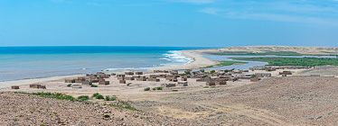 clay brick houses with no roof near river mouth along coast