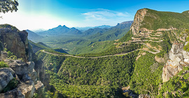 road hairpins climbing green escarpment