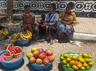 women selling fruits & veggies along road