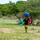 woman carrying plastic chairs from river clothinglaundry